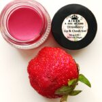 A container of strawberry lip balm, offering moisturizing and nourishing care for soft, smooth lips with a sweet fruity fragrance.